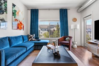 Living room with blue velvet sectional and view window